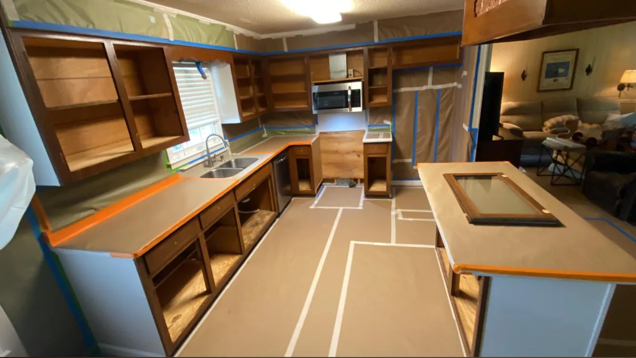 Cabinet doors removed and kitchen surfaces masked for preparation