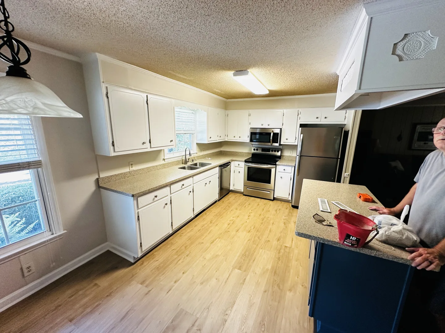 White cabinets and a blue kitchen island in a Denmai project