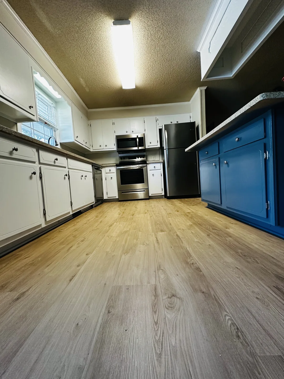 White kitchen cabinets with a deep blue island from Denmai’s project gallery